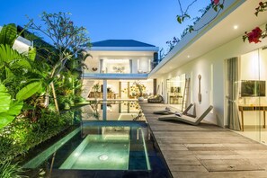 A modern house with a swimming pool, a covered patio, and a well-maintained garden. - Villa Hugo (Canggu)