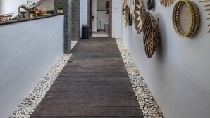 A modern interior with a wooden floor, a stone accent wall, and a skylight. - Villa Hugo (Canggu)