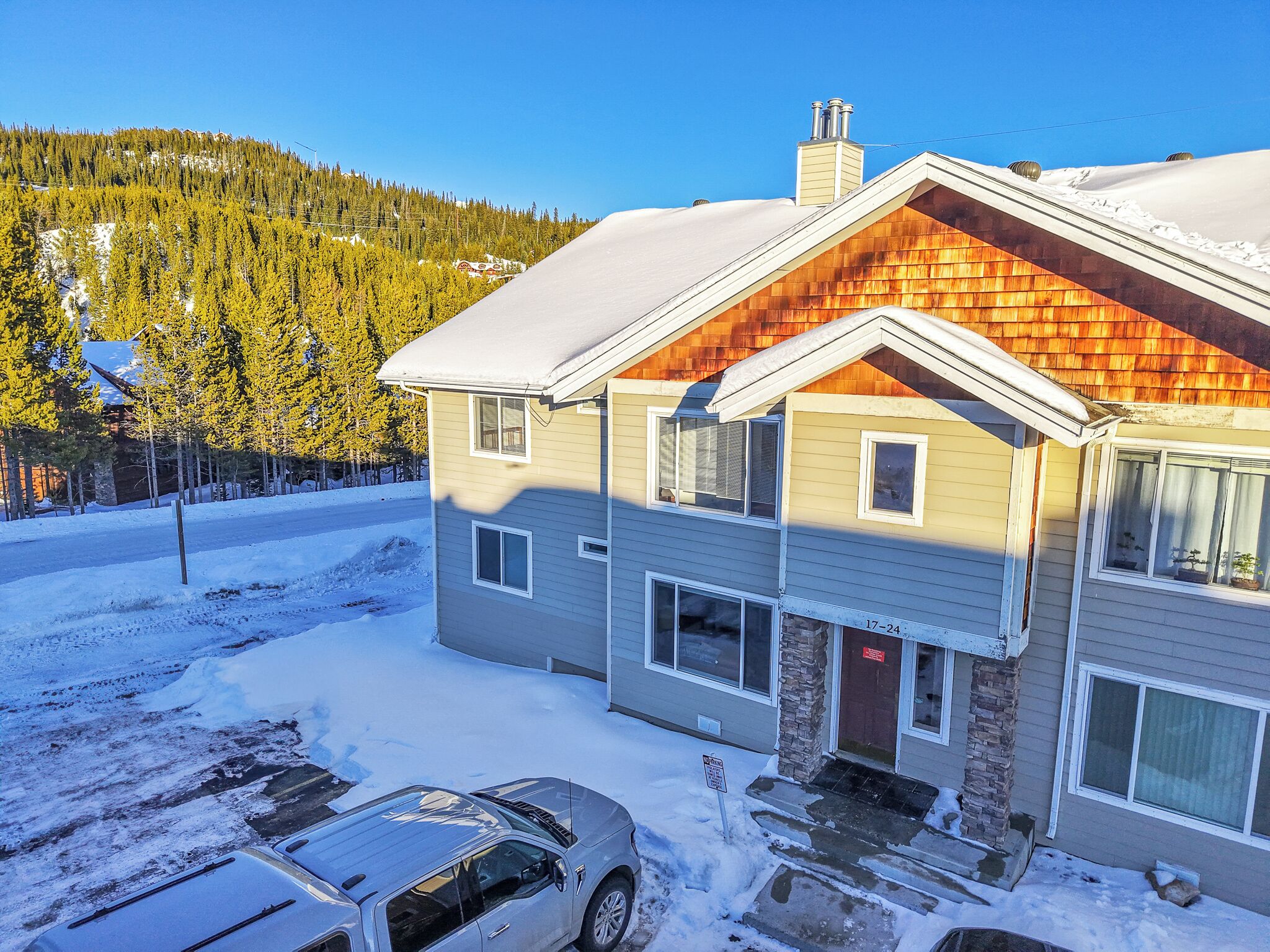 A two-story house with a sloped roof, a chimney, and a garage.