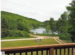 Overlooking a serene lake, this lakeside retreat offers a peaceful escape surrounded by lush greenery and a well-manicured lawn.