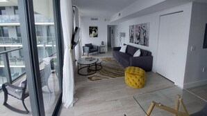 Ein modernes Wohnzimmer mit einer Couch, Hocker und Couchtisch.