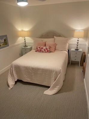 A neatly made bed with a quilted cover, two bedside tables with lamps, and a framed picture on the wall. - Beachy Home in Provo. Large deck with builtin hot tub, Fire pit, Palapa (Provo)