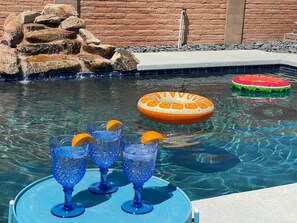 A pool with clear water, a rock formation, and an inflatable float. - Oasis! BEST LOCATION! Private Pool! By Restaurants (Chandler)