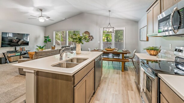 A modern kitchen with a central island, built-in appliances, and a dining area with a view of the outdoors. - Cheerful  NEW Executive Home with office-Meridian (Meridian)