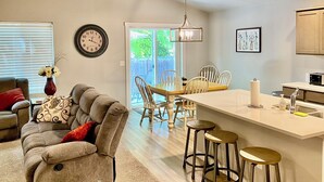 A modern kitchen with a central island, bar stools, and a dining area with chairs. - Cheerful  NEW Executive Home with office-Meridian (Meridian)