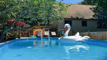 Relax by the pool with a fun play area for kids featuring a slide and a swan float.