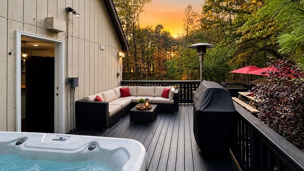 Une terrasse dotée d’un jacuzzi, d’un espace salon extérieur et d’un barbecue couvert.