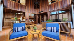 Eine geräumige Lobby mit Holzwandverkleidung, einer Bar und Sitzgelegenheiten mit blauen Kissen.
