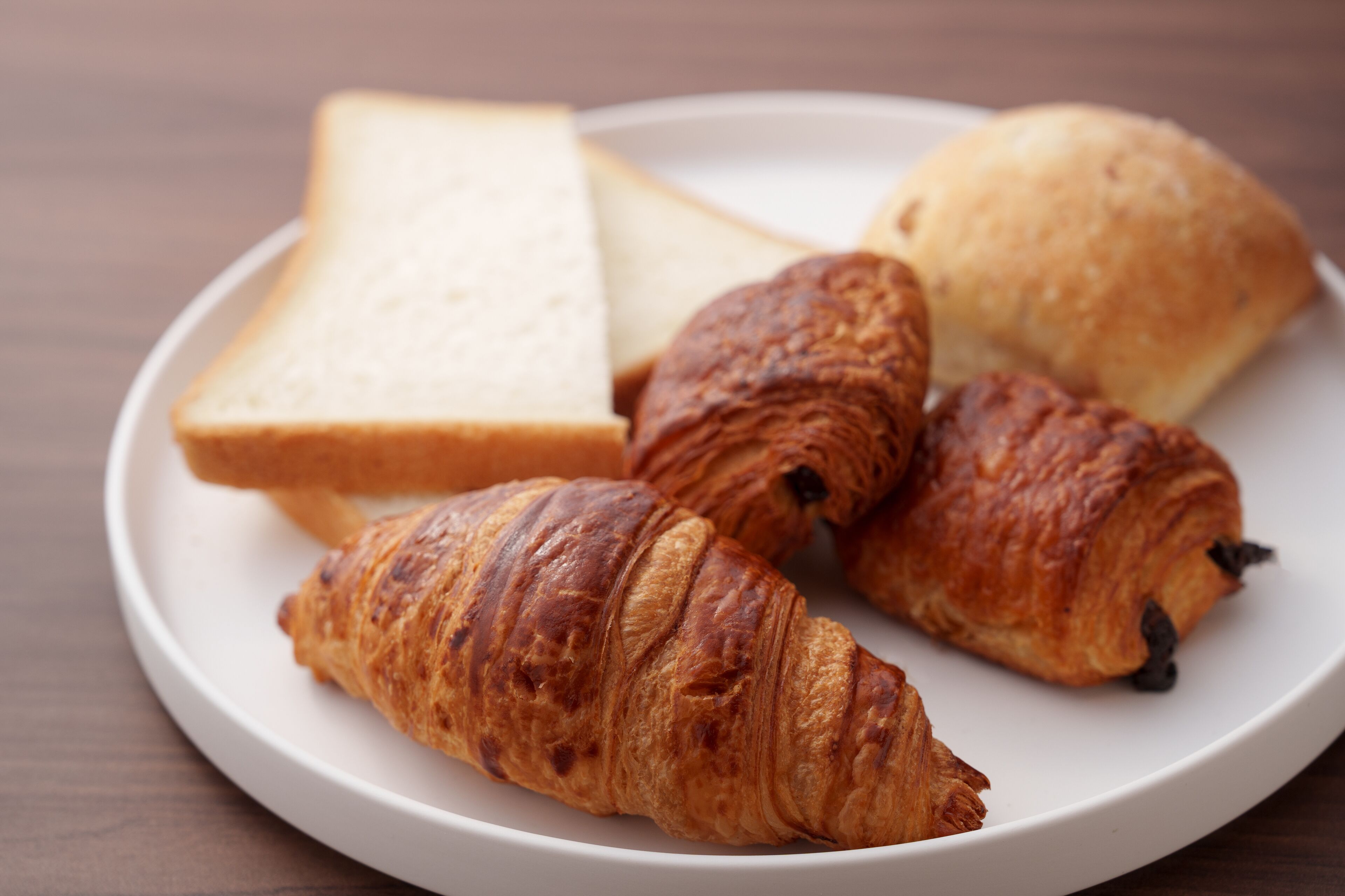 Une assiette avec des croissants et des tranches de pain.