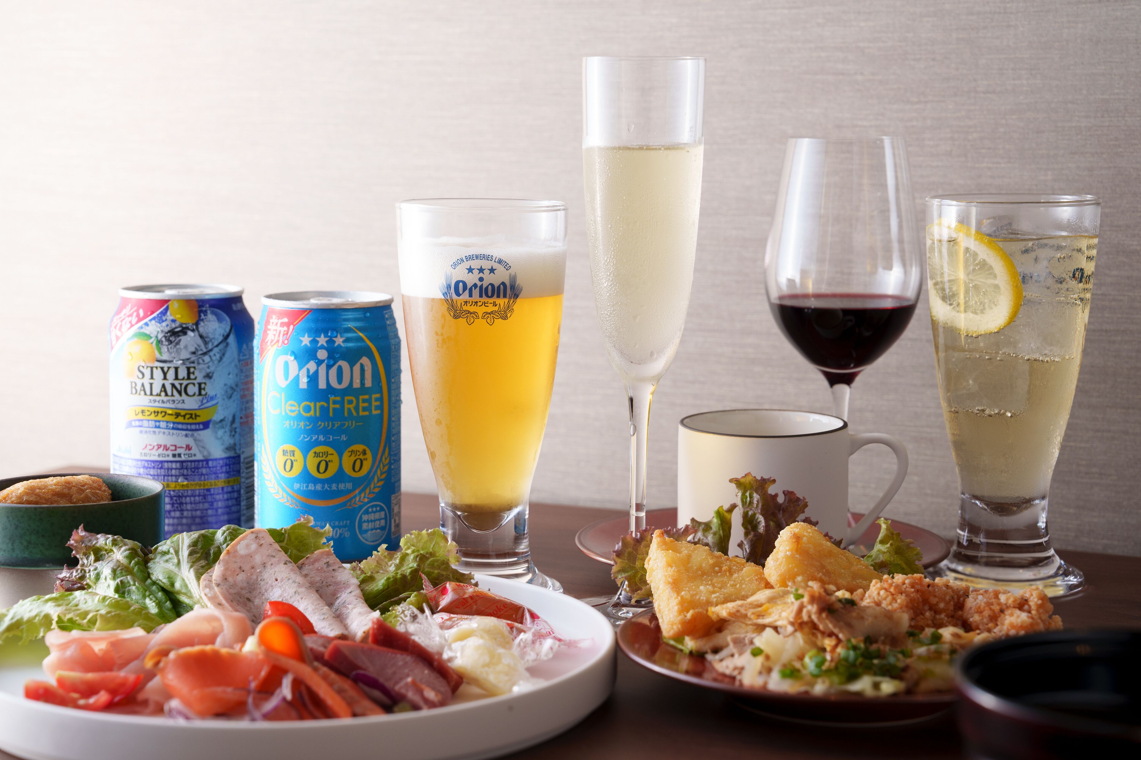 Une table sur laquelle on trouve divers aliments, des boissons et des canettes de bière.