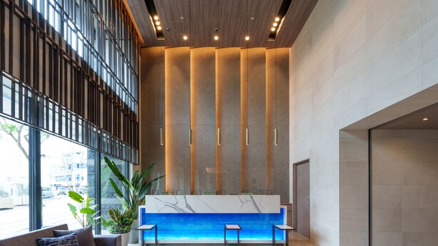 A modern reception area with a marble counter, seating, and large windows. - Hotel Grand Consort Naha (Naha)