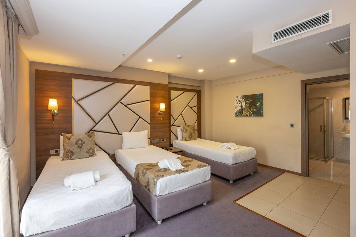 Une chambre d’hôtel avec deux lits, une salle de bain et une douche.