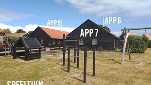 A playground with wooden structures labeled APP5, APP6, and APP7, and a swing set. - Newly renovated apartments on large grounds (Hollum)