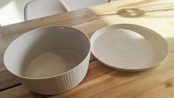 Two white ceramic bowls with textured patterns on a wooden table.