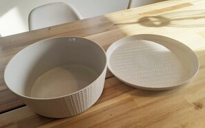Two white ceramic bowls with textured patterns on a wooden table.