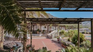 A covered outdoor area with a stone staircase, potted plants, and a view of a mountain. - Pet-Friendly 'Finca Rural Los Tanquillos' with Mountain View, Pool, Wi-Fi, A/C, Terrace & Garden (San Bartolomé de Tirajana)