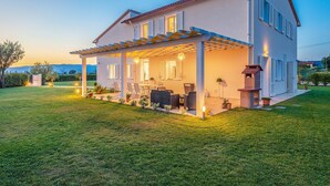 A two-story house with a covered patio, outdoor seating, and a well-maintained lawn. - Villa Le Terme with Pool, Whirlpool, Garden, Terrace, BBQ, A/C & Wi-Fi (Monsummano Terme PT)