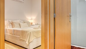 A bedroom with a bed, bedside table, and an air conditioning unit. - Casa Familia Pestana 1, a Home in Madeira (Seixal)