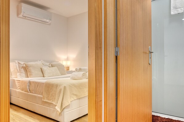 Une chambre à coucher comprenant un lit, une table de chevet et un appareil de climatisation.