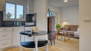 Un espacio habitable compacto con cocina, comedor y zona de estar.