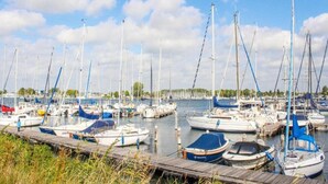 A marina with multiple boats docked at wooden piers. - Apartment in Zeeland with Private Jetty (Kamperland)