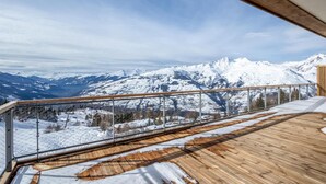 A wooden deck with a glass balustrade overlooking a snowy mountain landscape. - 50m from ski slopes, 1st floor, view panoramic, fitness, swimming pool, sauna, hammam, terrace (Bourg-Saint-Maurice)