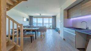 A modern apartment with a wooden staircase, a dining area, a living room with a view, and a kitchen with a built-in island. - 50m from ski slopes, 1st floor, view panoramic, fitness, swimming pool, sauna, hammam, terrace (Bourg-Saint-Maurice)