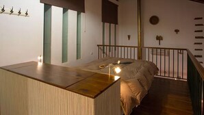 Une chambre moderne avec un lit surélevé en bois, un escalier et une décoration minimaliste.