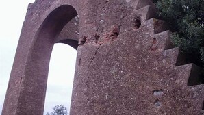 Une structure en pierre dotée d’une ouverture en arc et d’un escalier menant à celle-ci.