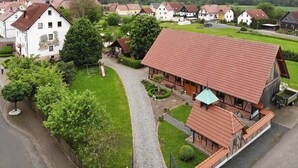 A traditional European village with a central building featuring a red-tiled roof, surrounded by smaller houses with similar architecture. - Landhotel Zur Pferdetränke (Schleid)