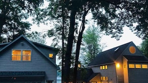 A two-story house with a garage, large windows, and a porch with string lights.