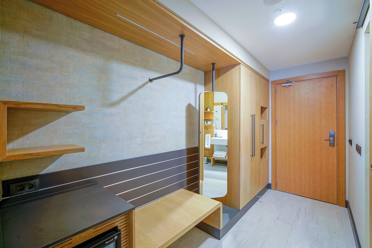 A modern bathroom with a wooden vanity, a mirror, and a shower area.