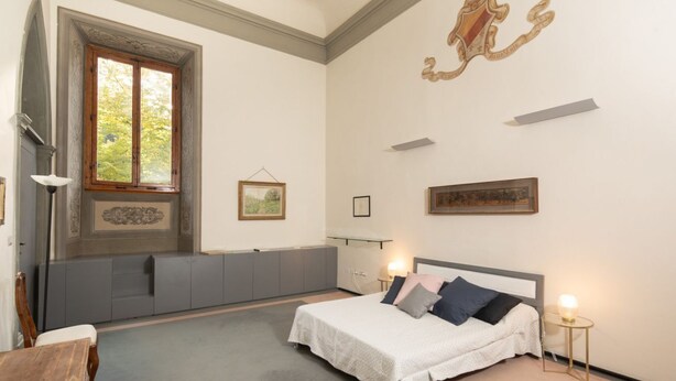 A bedroom with a bed, bedside tables, a window, and wall-mounted artwork. - Fantastic 3 bedroom apartment in the heart of Florence (Firenze)