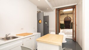 A compact kitchen with a sink, a wooden cutting board, and a small dining table. - Fantastic 3 bedroom apartment in the heart of Florence (Firenze)