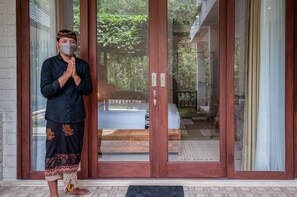 A person standing in front of a room with a bed and a wooden floor. - The Lokal Penida (Penida Island)