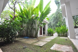 A garden with a pathway leading to a building. - The Lokal Penida (Penida Island)