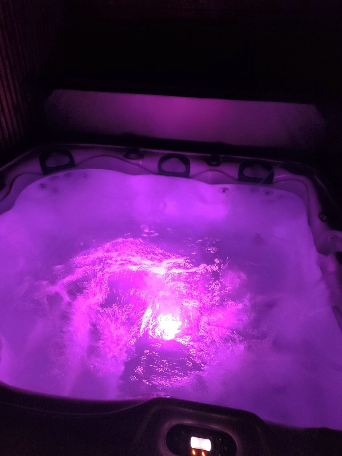 Un jacuzzi con luz púrpura.