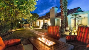 A patio area with a fire pit table, outdoor seating, and a pathway leading to a house. - Desert Retreat - Walk to Indian Wells Tennis (Palm Desert)