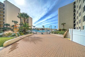 Ein Hotel mit Swimmingpool, Palmen und einem Wegweiser mit Beschilderung.