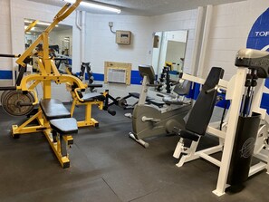 A gym with various exercise equipment, including a bench press, a squat rack, and a cable machine. - FREE Golf+Perks!Top of the Gulf Beachfront 703 Spacious Studio w/Great Views! (Panama City Beach)