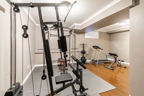 A home gym with a pull-up bar, bench press, and weight bench. - GLOBALSTAY. Luxury 3BR Townhomes with HOT TUB, Gym, BBQ (Hamilton)