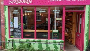 A storefront with a green and pink facade, labeled as an organic juice bar. - Special 3 Bedroom Townhouse With Parking in Bristol (Bristol)