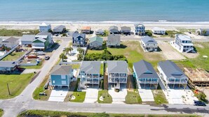 Zona residencial costera con casas, una playa y cielo despejado.