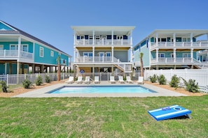 Un bâtiment à deux étages doté d’une piscine, de rampes blanches et d’une décoration aux couleurs bleu et blanc.
