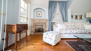 A room with a fireplace, a sofa, a table, and a patterned rug. - HbHall - Duomo Suite 7 Apartment (Milan)