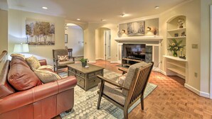 A living room with a leather sofa, wooden armchair, and a fireplace. - Easy Hiking & Sightseeing! Kingsport Home w/ Deck (Kingsport)