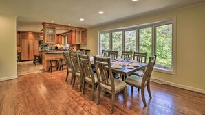 A spacious kitchen with wooden cabinets, a dining area with a large window, and hardwood flooring. - Easy Hiking & Sightseeing! Kingsport Home w/ Deck (Kingsport)
