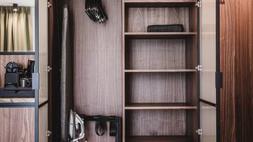 Un vestidor con estantes de madera, espacio para colgar ropa y una caja fuerte empotrada.