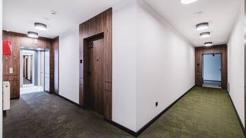 A hallway with wooden paneling, a green carpet, and a door marked with the number 22.