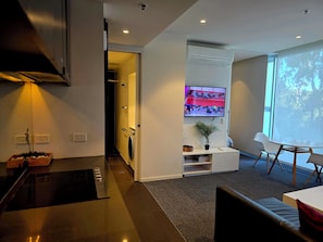 Una sala de estar moderna con un televisor de pantalla plana, un comedor y una cocina.